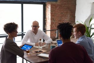 Photo Of People Sitting Beside Wooden Table